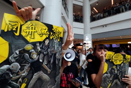 Anti-government protesters hold placards at Olympian City 2 shopping mall in Hong Kong