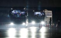 Buses believed to carry the U.S. passengers of the cruise ship Diamond Princess, where dozens of passengers were tested positive for coronavirus, leave at Daikoku Pier Cruise Terminal in Yokohama, south of Tokyo