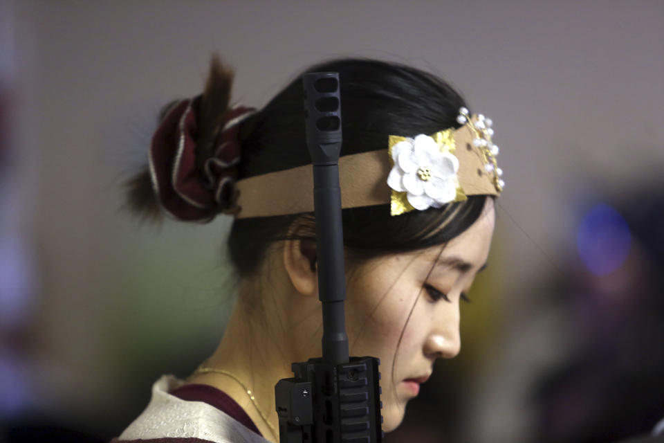 <p>A standing woman holds an unloaded weapon during services at the World Peace and Unification Sanctuary, Wednesday Feb. 28, 2018 in Newfoundland, Pa. (Photo: Jacqueline Larma/AP) </p>