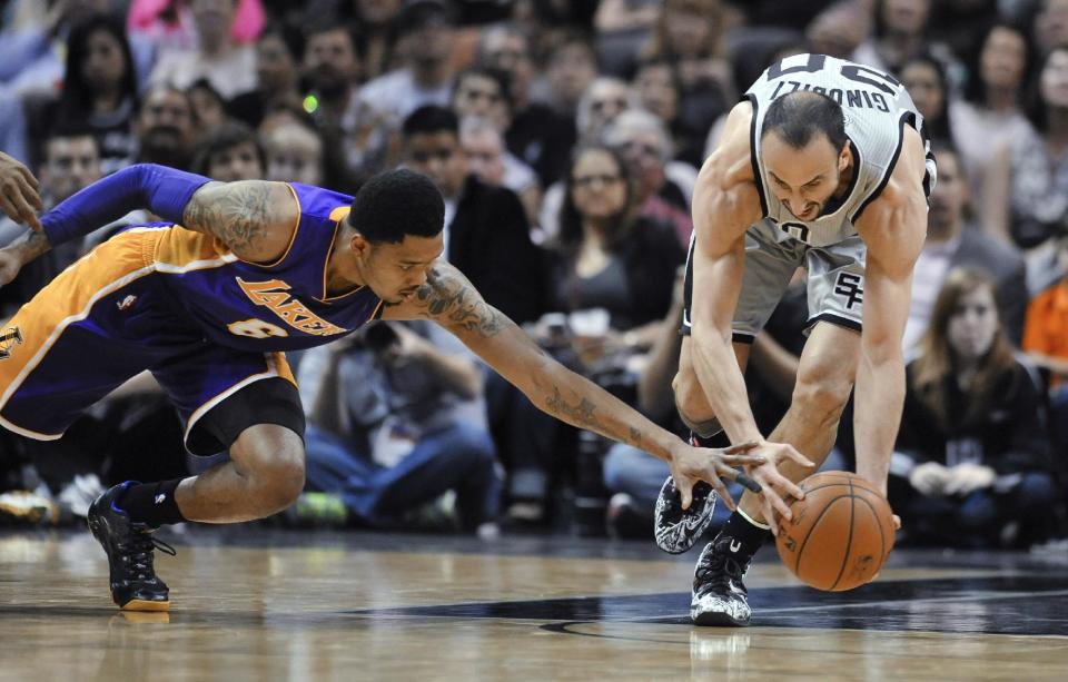 San Antonio Spurs guard Manu Ginobili, right, comes up with a loose ball in front of Los Angeles Lakers guard Kent Bazemore during the first half of an NBA basketball game Friday, March 14, 2014. (AP Photo/Bahram Mark Sobhani)