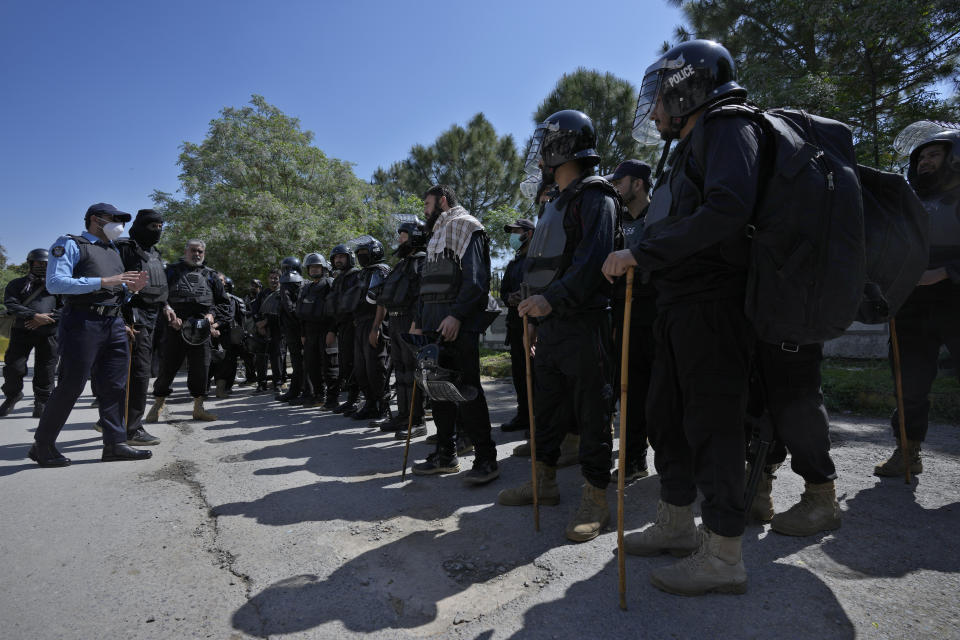 Riot police officers stand guard outside a court where former Prime Minister Imran Khan appeared for his case, in Islamabad, Pakistan, Monday, March 27, 2023. A Pakistani court ruled in defense of former Prime Minister Khan, granting him protection from arrest as lawsuits mounted against the ousted premier, with police charging him with incitement to violence in several cases when his followers clashed with the security forces this month. (AP Photo/Anjum Naveed)