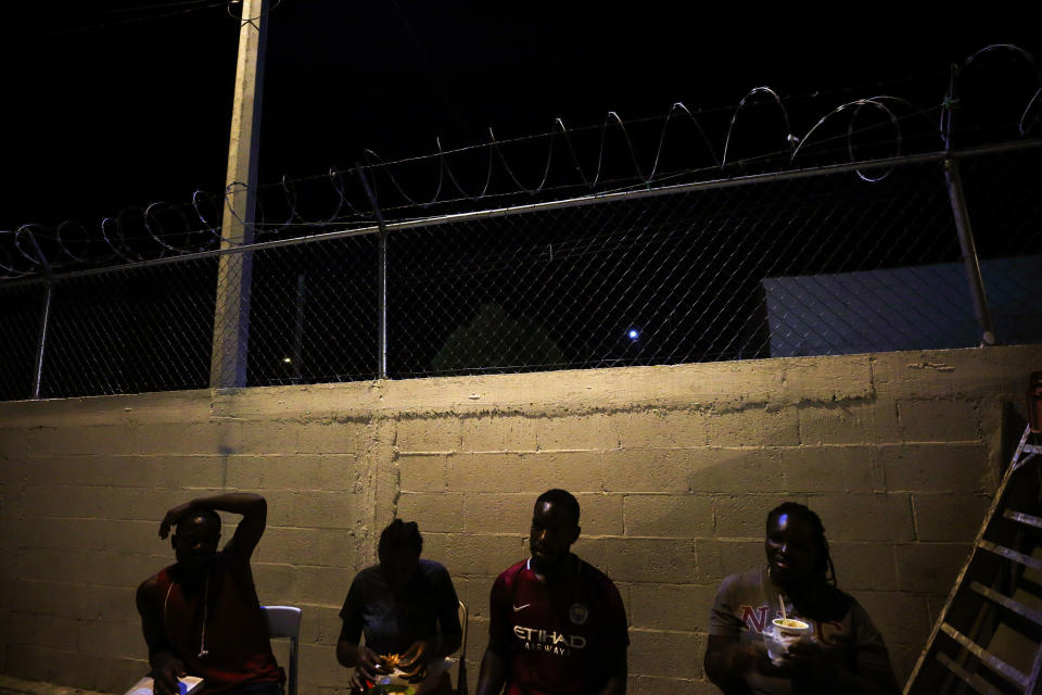 CORRECTS TRANSLATION OF PASTOR TO SHEPHERD - In this July 24, 2019, photo, Africans sit in folding chairs at Buen Pastor migrant shelter in Cuidad Juarez, Mexico. They are part of the cobbled-together community of El Buen Pastor, or The Good Shepherd, 134 migrants from around the world locked into a shelter every evening at 5:30 p.m., trapped in an immigration purgatory barely three miles from the Paso del Norte Bridge and an easy walk to their goal: The United States. (AP Photo/Gregory Bull)