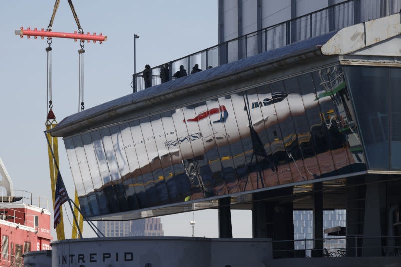 Workers prepare the British Airways Concorde to be lifted by cane on to Pier 86 at the Intrepid Museum in New York City. The iconic jet has been at the museum since 2003 and was removed for the first time in August to undergo renovations. Photo by John Angelillo/UPI