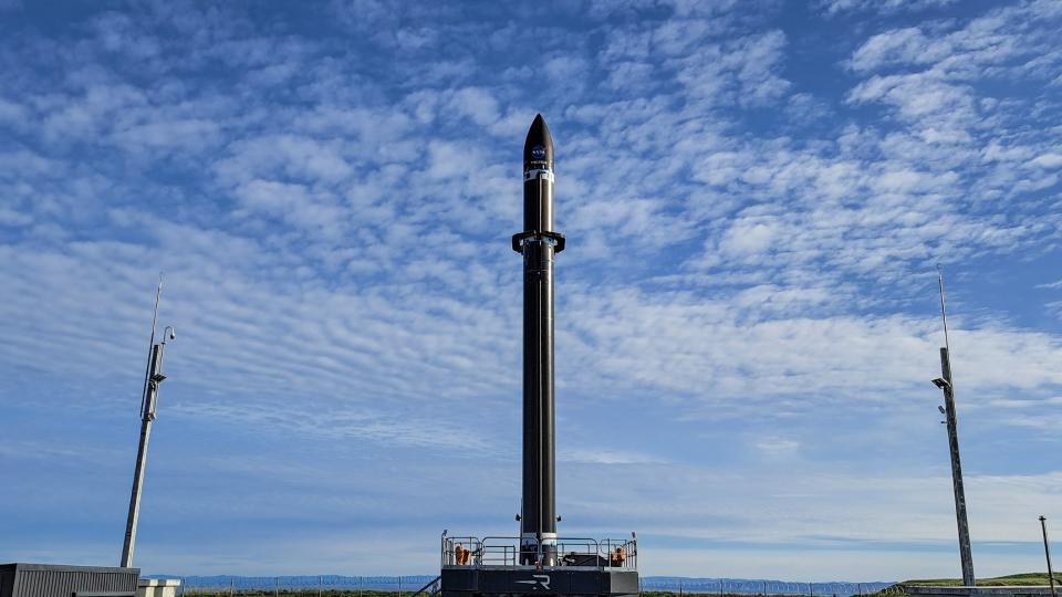 a black rocket upright on a launch pad