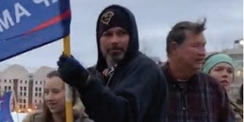 Michael Perkins holding a Trump flag.