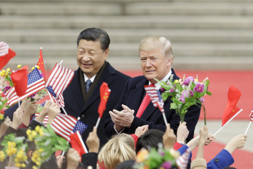 FILE: U.S. President Donald Trump, right, and Xi Jinping, China's president, greet attendees waving American and Chinese national flags during a welcome ceremony outside the Great Hall of the People in Beijing, China, on Thursday, Nov. 9, 2017. Sunday, January 20, 2019, marks the second anniversary of U.S. President Donald Trump's inauguration. Our editors select the best archive images looking back over Trumps second year in office. Photographer: Qilai Shen/Bloomberg via Getty Images