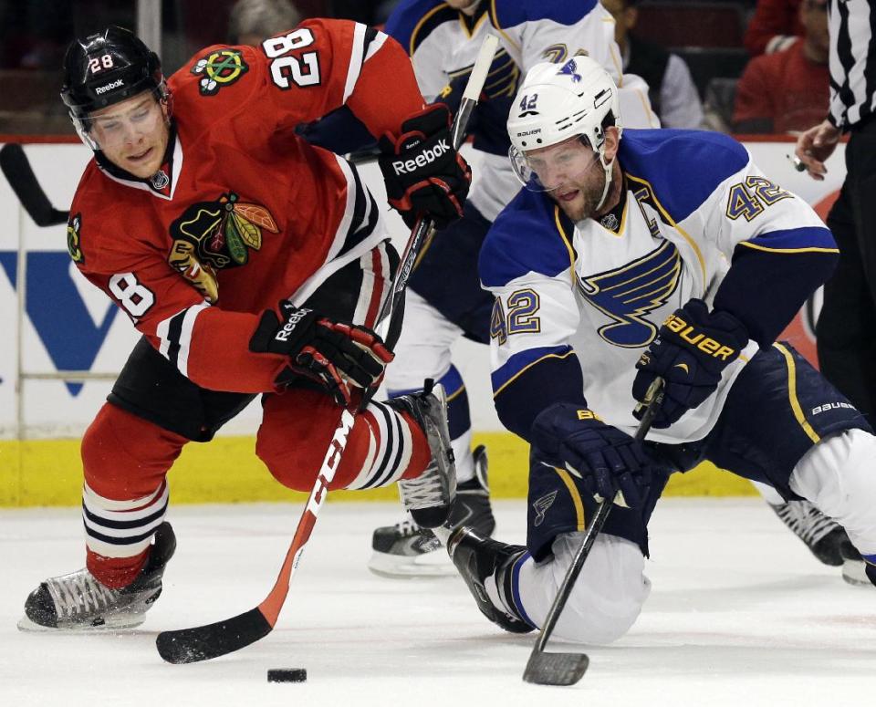 Chicago Blackhawks' Ben Smith, left, and St. Louis Blues' David Backes battle for the puck during the first period in Game 6 of a first-round NHL hockey playoff series in Chicago, Sunday, April 27, 2014. (AP Photo/Nam Y. Huh)