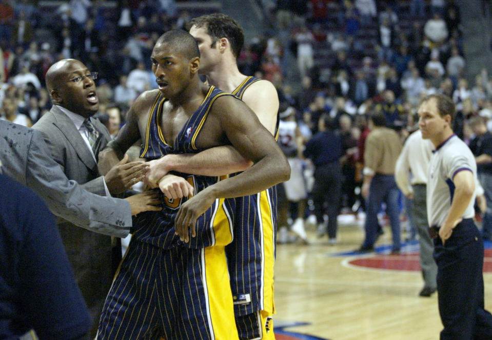 FILE - In this Nov. 19, 2004 file photo, Indiana Pacers' Ron Artest is restrained before being escorted off the court following a fight with the Detroit Pistons and fans in Auburn Hills, Mich. Artest, now known as Metta World Peace and with the New York Knicks, believes Marcus Smart can learn from the fallout that will come after the Oklahoma State All-American shoved a fan during an NCAA college basketball game at Texas Tech on Saturday, Feb. 8, 2014. Smart was suspended three games by the Big 12 on Sunday. (AP Photo/Duane Burleson, File)