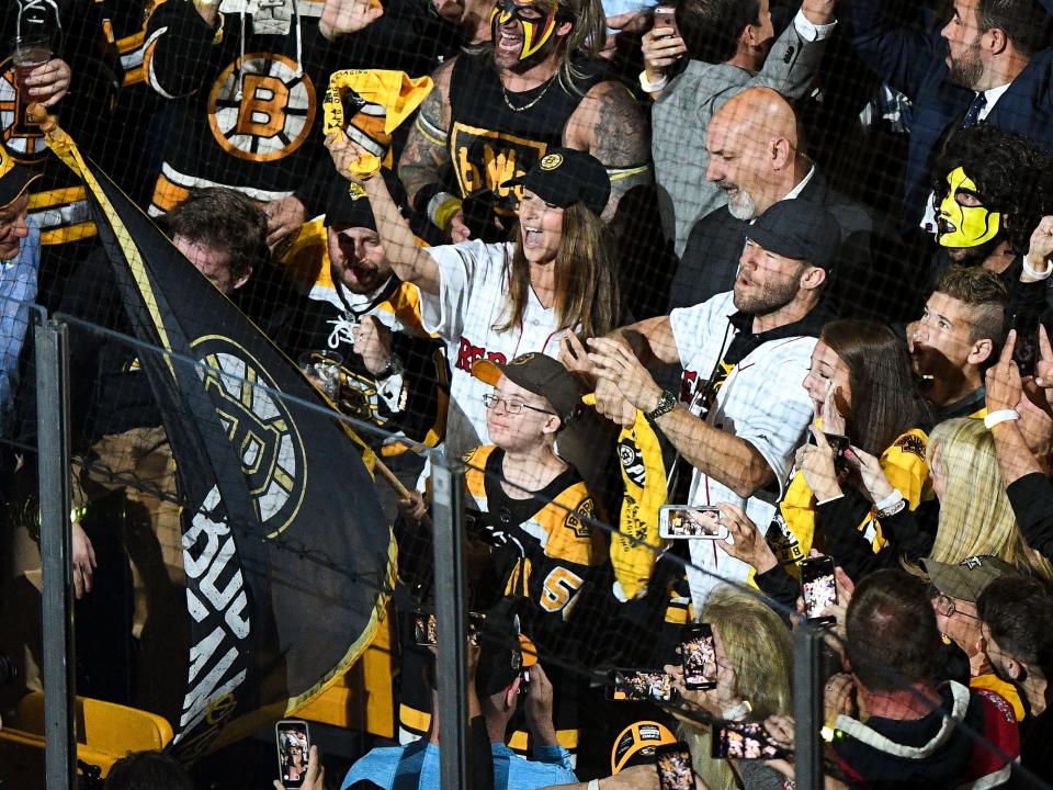 Jun 12, 2019; Boston, MA, USA; Olympic gymnast  Aly Raisman, New England Patriot player Julian Edelman wearing David Ortiz No. 34 Red Sox jerseys, and Liam Fitzgerald wave a flag before a game between the Boston Bruins and the St. Louis Blues in game seven of the 2019 Stanley Cup Final at TD Garden.