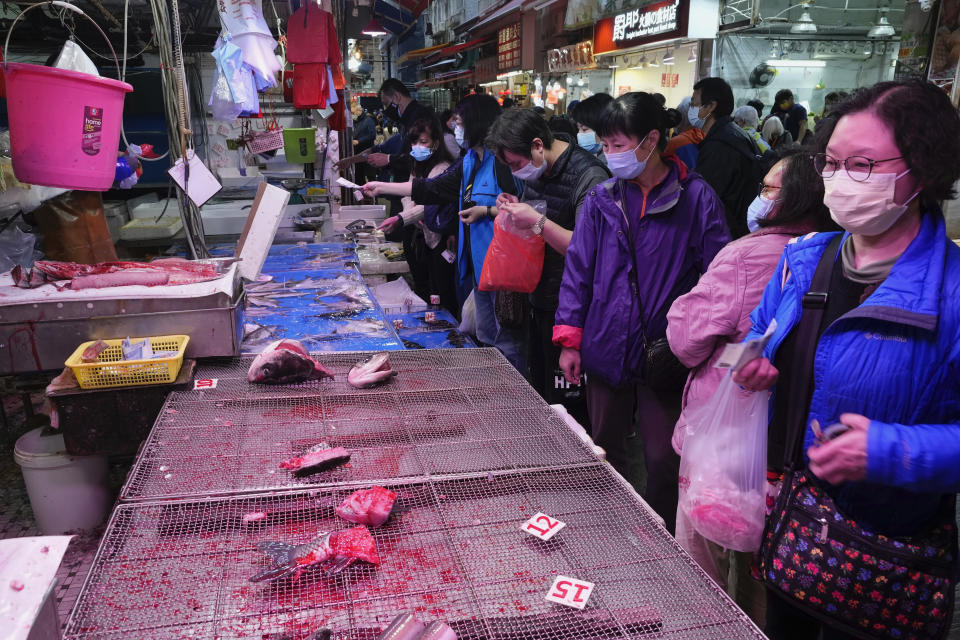 People wearing face masks purchase the last pieces of fish at a stall as residents worry about a shortage of fresh food in Hong Kong, Monday, Feb. 28, 2022. Hong Kong on Monday reported a record-high 34,466 infections, with health authorities saying that a lockdown has not been ruled out as fatalities continued to climb. (AP Photo/Vincent Yu)