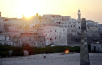 A man walking past the old buildings of the southern Somalia port town of Merka