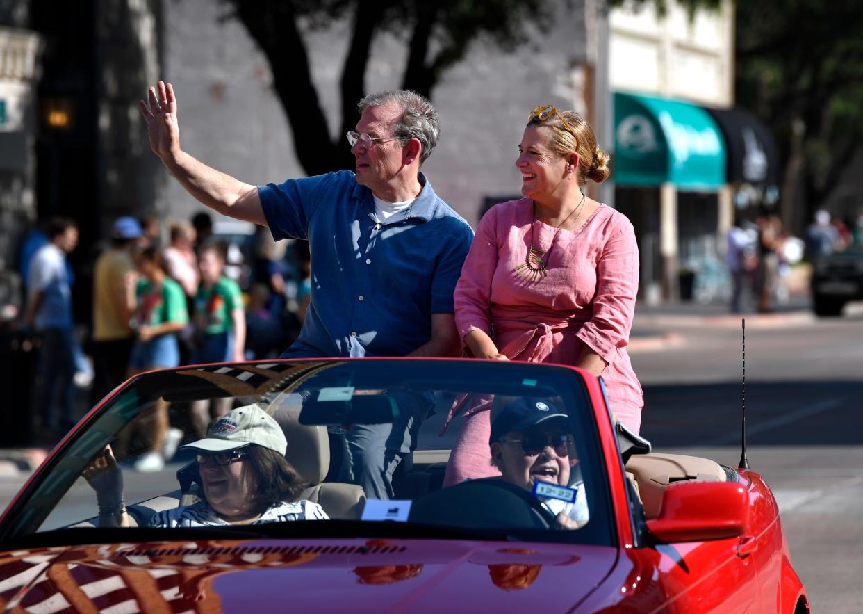 Artist Sophie Blackall and her husband Ed Schmidt wave from the back of a sports car during Thursday's Children's Art & Literacy Festival. At Adamson-Spalding Storybook Garden, they unveiled the sculpture of her creation of Winnie.