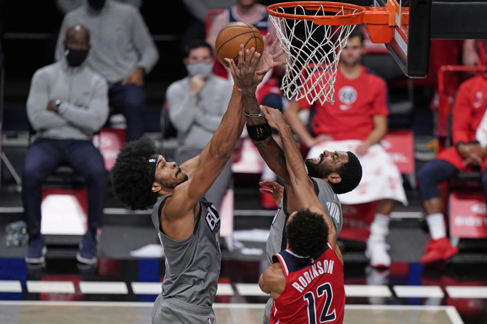 Brooklyn Nets center Jarrett Allen, left, and guard Kyrie Irving, center, battle for a rebound in front of Washington Wizards guard Jerome Robinson, right, during the second quarter of an NBA basketball game, Sunday, Jan. 3, 2021, in New York. (AP Photo/Kathy Willens)