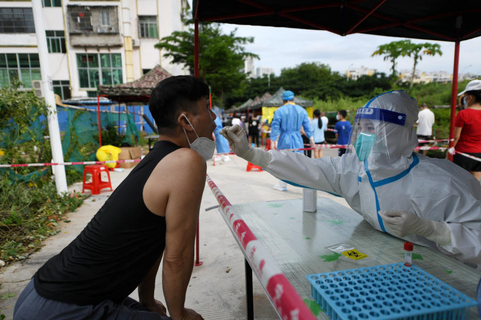 A medical worker takes a swab sample from a resident for the nucleic acid test at a makeshift testing site, amid lockdown measures to curb the coronavirus disease (COVID-19) outbreak in Sanya, Hainan province, China August 9, 2022. China Daily via REUTERS ATTENTION EDITORS - THIS IMAGE WAS PROVIDED BY A THIRD PARTY. CHINA OUT.