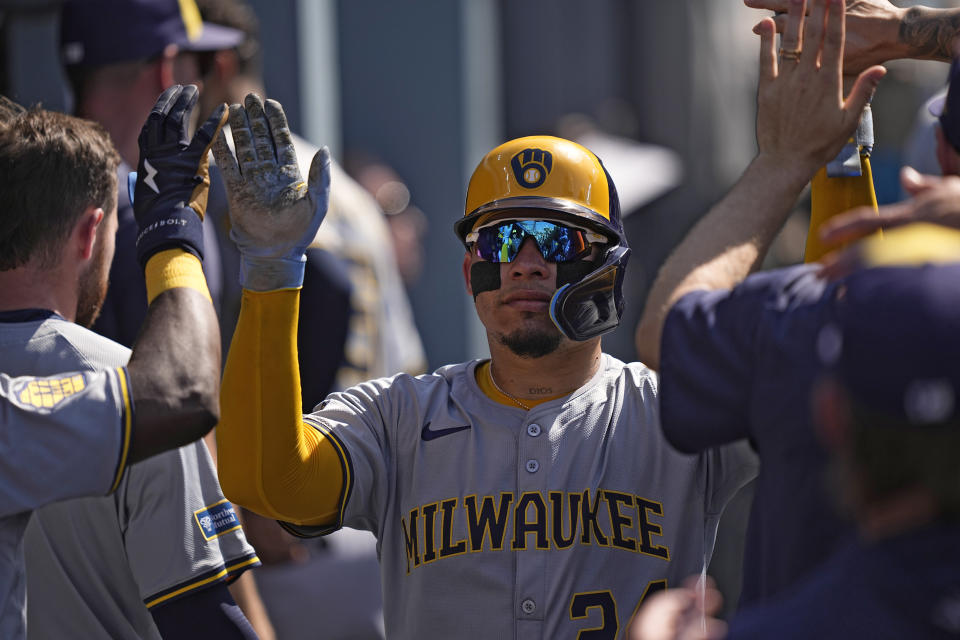 Milwaukee Brewers' William Contreras is congratulated by teammates in the dugout after scoring on a single by Willy Adames during the first inning of a baseball game against the Los Angeles Dodgers Saturday, July 6, 2024, in Los Angeles. (AP Photo/Mark J. Terrill)