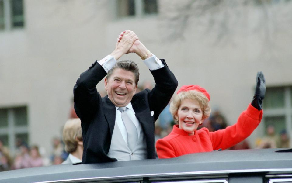 Reagan with wife Nancy at the inauguration parade in 1981. The hostages were released minutes after his speech - EPA