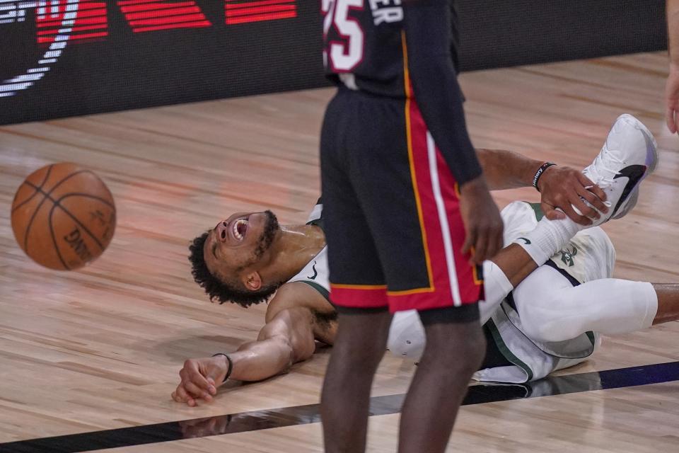 Milwaukee Bucks' Giannis Antetokounmpo reacts in pain on the basketball court.