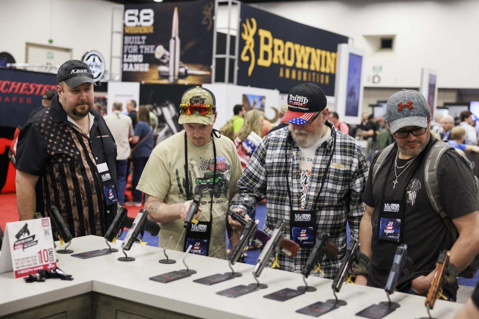 Men check out pistols on display at the National Rifle Association’s annual meeting in Indianapolis in 2023. <a href="https://www.gettyimages.com/detail/news-photo/guests-check-out-pistols-on-display-at-the-national-rifle-news-photo/1251837074?adppopup=true" rel="nofollow noopener" target="_blank" data-ylk="slk:Jeremy Hogan/SOPA Images/LightRocket via Getty Images;elm:context_link;itc:0;sec:content-canvas" class="link ">Jeremy Hogan/SOPA Images/LightRocket via Getty Images</a>