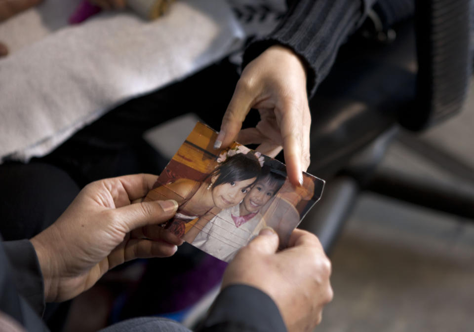 In this Aug. 27, 2013 photo, Jackilyn Yulip, from the Phillipines, shows a photo of her children Yuli, left, and Rudy as she serves jail time for drug trafficking at the Piedras Gordas prison on the outskirts of Lima, Peru. In Peru, drug mule sentences range that minimum to 15 years. But inmates must stay in the country, even if paroled, until their full sentence ends and they’ve paid their fines. (AP Photo/Martin Mejia)