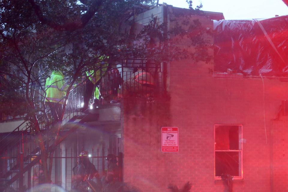 First responders tend to an injured person on a second-floor balcony after a partial building collapse in the 2100 block of Washington Avenue as Hurricane Zeta strikes the New Orleans metro area on Wednesday, Oct. 28, 2020, in New Orleans, LA.