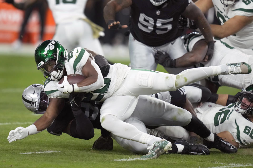 New York Jets running back Breece Hall, top, is stopped by Las Vegas Raiders defensive tackle Bilal Nichols during the first half of an NFL football game Sunday, Nov. 12, 2023, in Las Vegas. (AP Photo/John Locher)