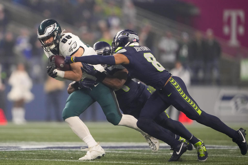 Philadelphia Eagles tight end Dallas Goedert (88) runs with the ball after making a catch as Seattle Seahawks linebacker Bobby Wagner, center, and cornerback Coby Bryant (8) try to stop him during the first half of an NFL football game, Monday, Dec. 18, 2023, in Seattle. (AP Photo/Lindsey Wasson)