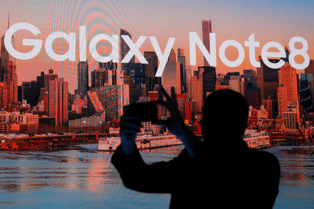 A man takes a picture with a smartphone at Samsung Electronics' Mobile Communications launch event for the Galaxy Note 8 smartphone in New York City, U.S., August 23, 2017. REUTERS/Brendan McDermid