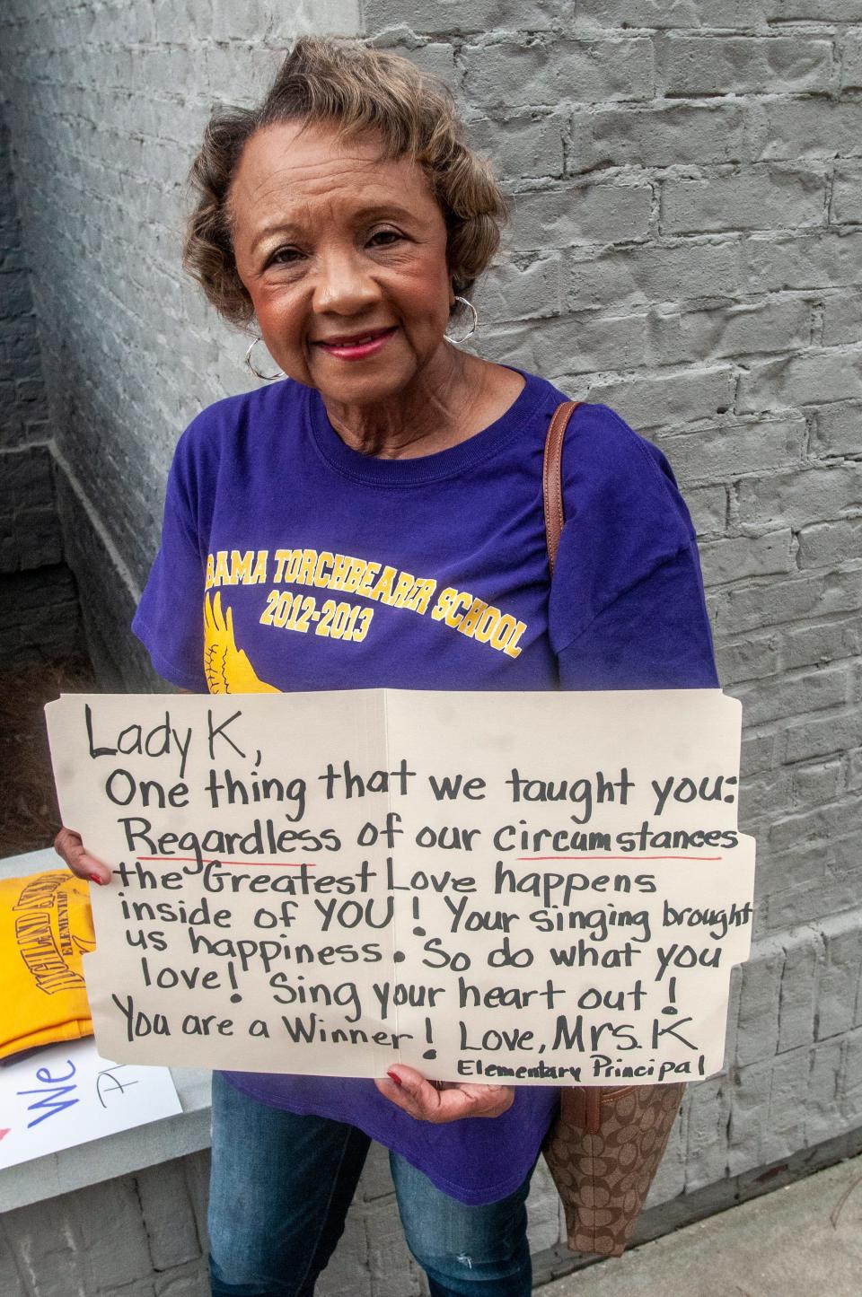 Former Highland Avenue Elementary principal Pat Kornegay holds a sign for her Montgomery native Lady K, who was a student at her school.