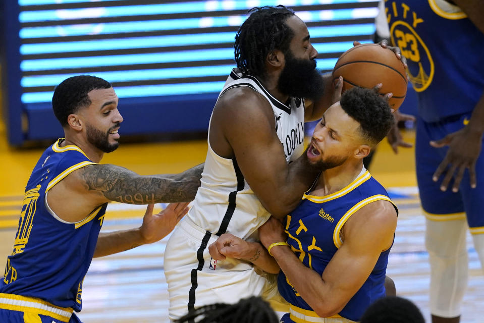 Brooklyn Nets guard James Harden, middle, is fouled by Golden State Warriors guard Stephen Curry, right, during the first half of an NBA basketball game in San Francisco, Saturday, Feb. 13, 2021. At left is Warriors guard Mychal Mulder. (AP Photo/Jeff Chiu)