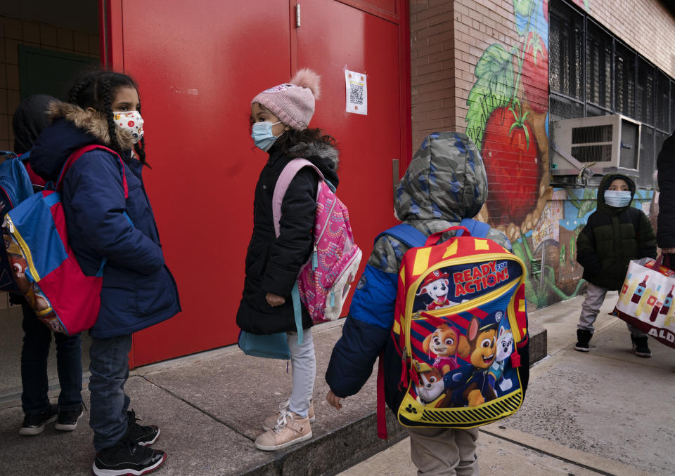 Students enter P.S. 134 Henrietta Szold Elementary School, Monday, Dec. 7, 2020, in New York. Public schools reopened for in-school learning Monday after being closed since mid-November. (AP Photo/Mark Lennihan)