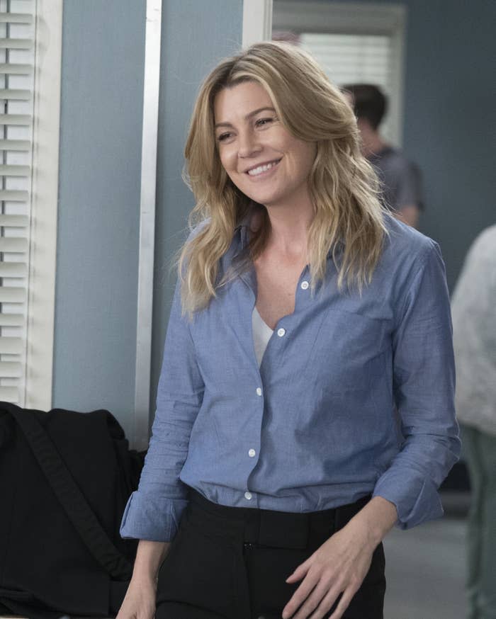 Ellen Pompeo smiles to someone off-camera on Grey's Anatomy