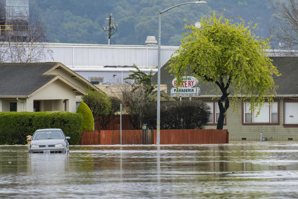 A vehicle is stuck in floodwaters in Watsonville, Calif., Saturday, March 11, 2023. Gov. Gavin Newsom has declared emergencies in 34 counties in recent weeks, and the Biden administration approved a presidential disaster declaration for some on Friday morning, a move that will bring more federal assistance. (AP Photo/Nic Coury)