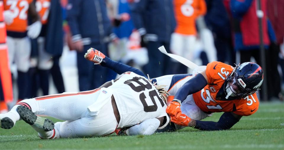 Denver Broncos safety Justin Simmons (31) pulls down Cleveland Browns tight end David Njoku (85) as he tries to make a catch in the second half Sunday in Denver.