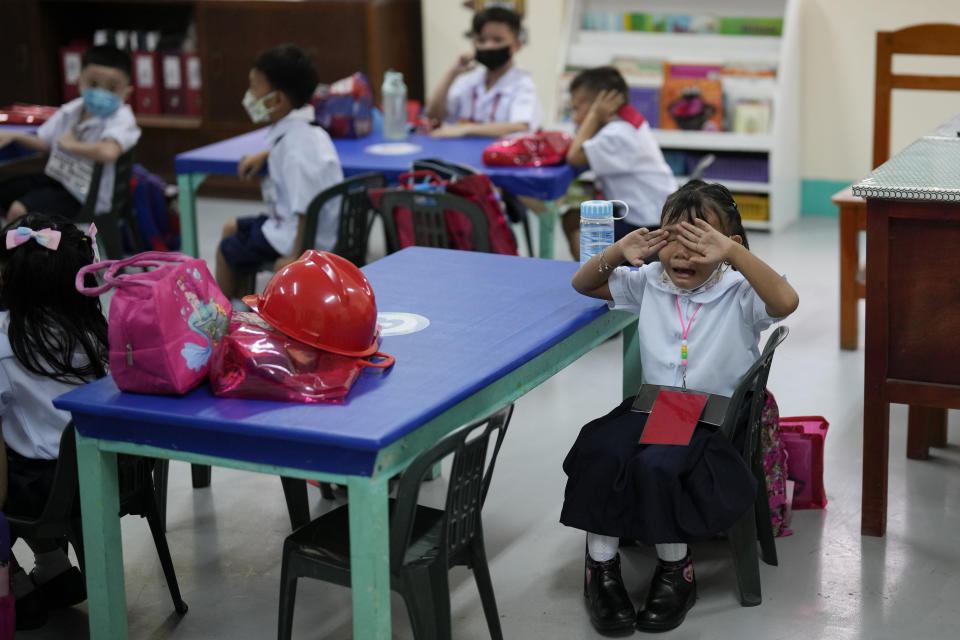 A girl cries during the opening of classes at the San Juan Elementary School in metro Manila, Philippines on Monday, Aug. 22, 2022. Millions of students wearing face masks streamed back to grade and high schools across the Philippines Monday in their first in-person classes after two years of coronavirus lockdowns that are feared to have worsened one of the world's most alarming illiteracy rates among children. (AP Photo/Aaron Favila)