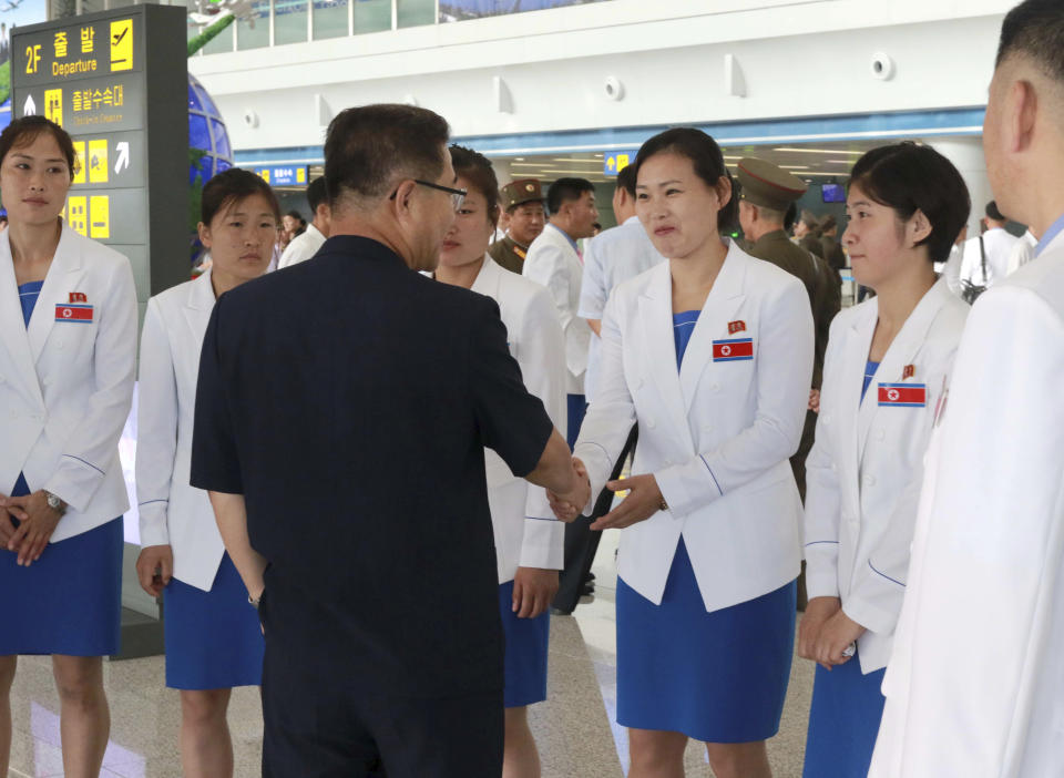 North Korean athletes, headed by North Korean Vice Sports Minister Won Kil U, are greeted before leaving the Pyongyang international airport in Pyongyang, North Korea, to participate in the 18th Asian Games Friday, Aug. 10, 2018. The war-separated rivals will take their reconciliation steps to the Asian Games in Jakarta and Palembang, Indonesia, where North and South Korea will jointly march in the opening ceremony and field combined teams in basketball, rowing and canoeing. (AP Photo/Cha Song Ho)