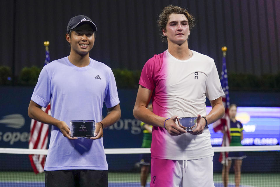 Joao Fonseca, of Brazil, right, holds the championship trophy while posing for a photo with Learner Tien, of the United States, after winning the junior boys singles final of the U.S. Open tennis championships, Saturday, Sept. 9, 2023, in New York. (AP Photo/Charles Krupa)
