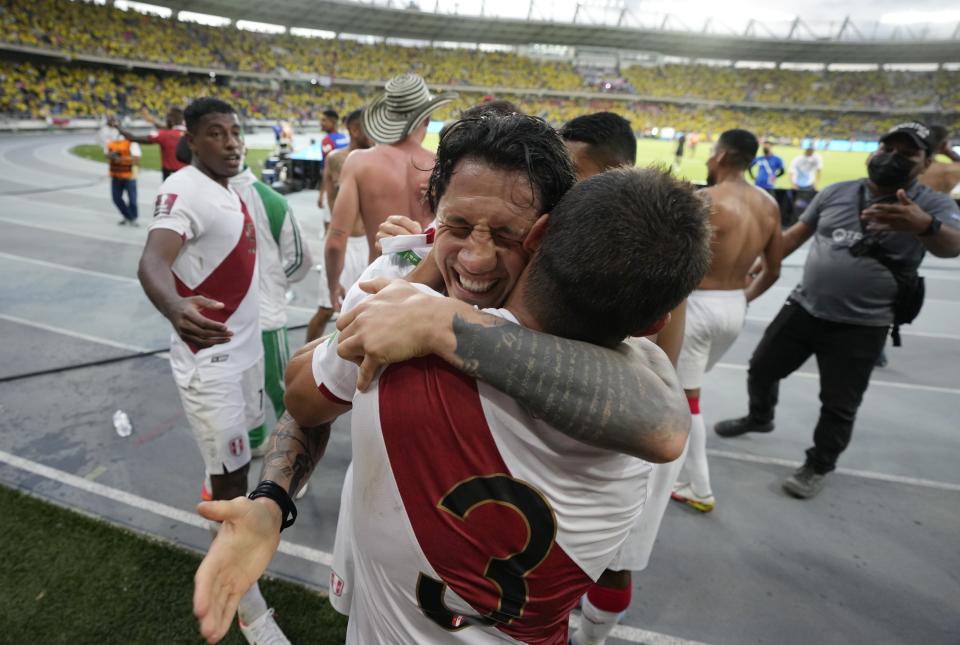 Peru's Aldo Corzo (3) and teammate Gianluca Lapadula embrace as they celebrate their 1-0 victory over Colombia at the end of a qualifying soccer match for the FIFA World Cup Qatar 2022 at Roberto Melendez stadium in Barranquilla, Colombia, Friday, Jan. 28, 2022. (AP Photo/Fernando Vergara)