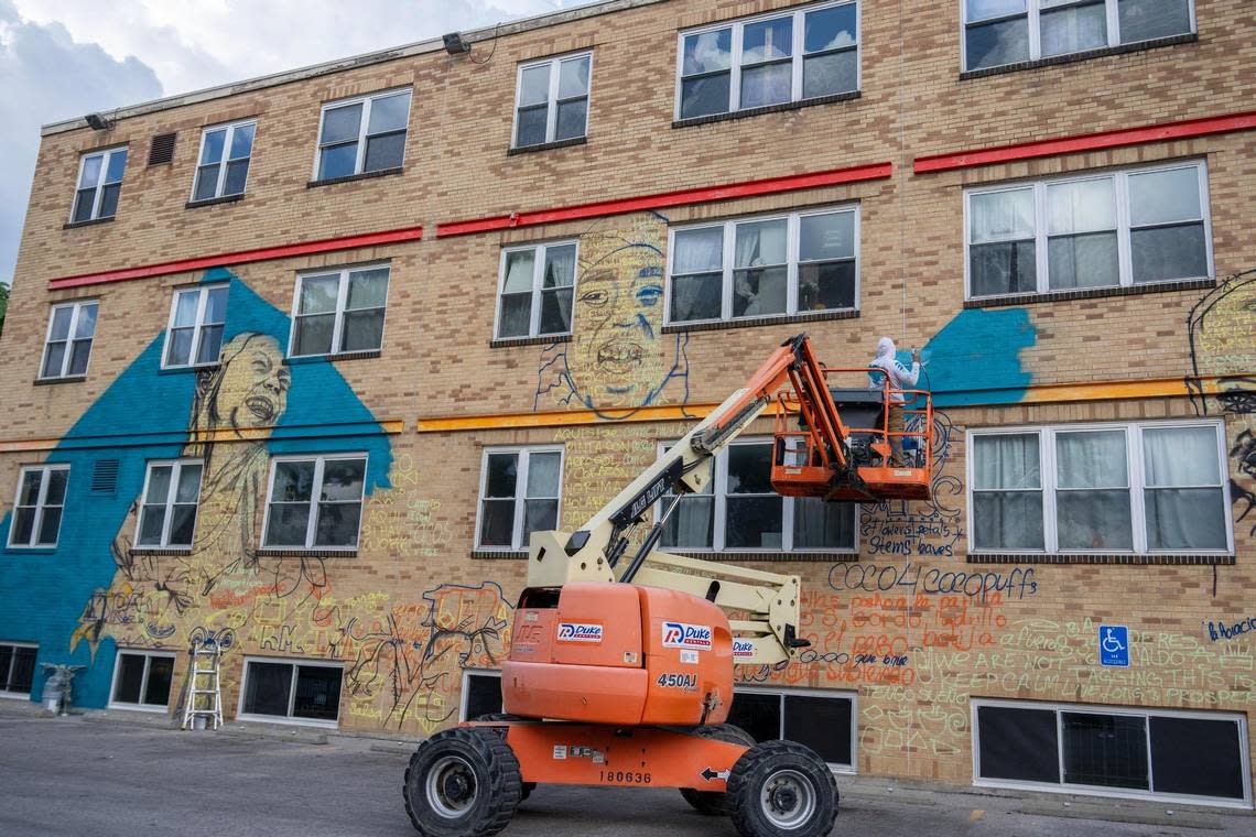 Isaac Tapia, left, and Rodrigo “Rico” Alvarez stand on a boom lift to begin their mural “Neighborhood Oasis” for the Mattie Rhodes Center.