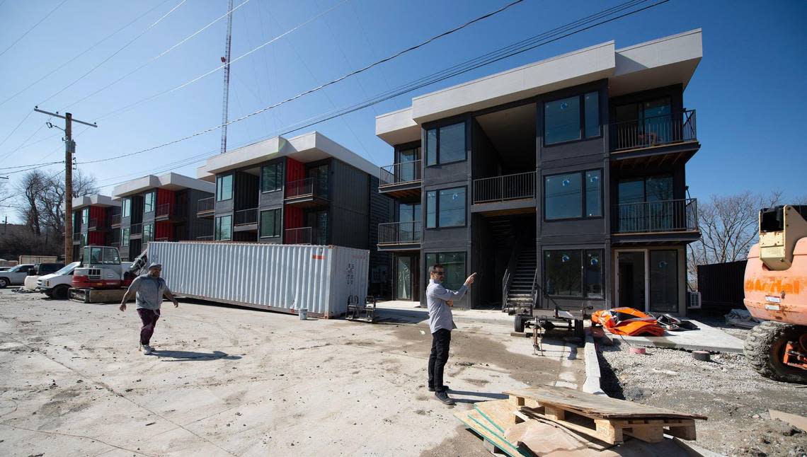 Signal Hill Studios, steel shipping container apartments, are rising above Kansas City’s West Side at 31st and Summit streets. Troy Paul, right, a partner with developer Paul Nagaoka, directs construction equipment.