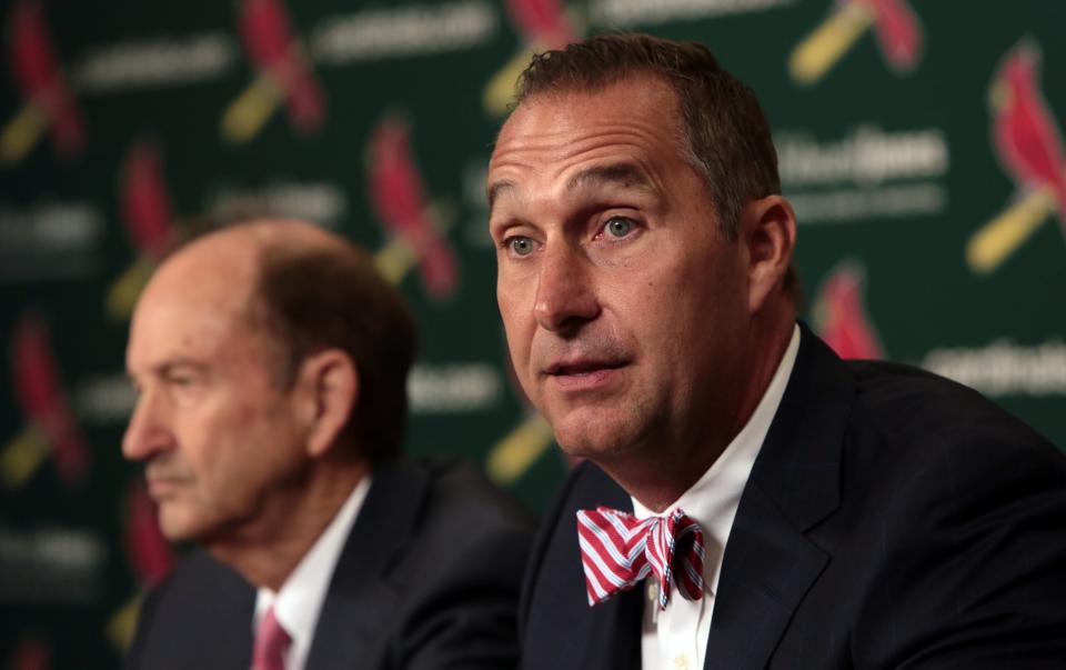 FILE - In this June 30, 2017, file photo, John Mozeliak, right, newly named St. Louis Cardinals president of baseball operations, speaks during a news conference at Busch Stadium in St. Louis. St. Louis' series opener against the Chicago White Sox has been postponed to Saturday, Aug. 15, 2020, giving the Cardinals an extra day to recover from a coronavirus outbreak. The Cardinals, who have not played since July 29, were set to resume their season Friday night in Chicago. But the series opener was pushed back to a doubleheader on Saturday, the beginning of an extended stay in the Windy City for the Cards. (Robert Cohen/St. Louis Post-Dispatch via AP, File)