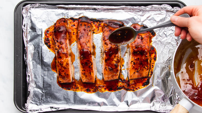 Sweet chili sauce being spooned over salmon