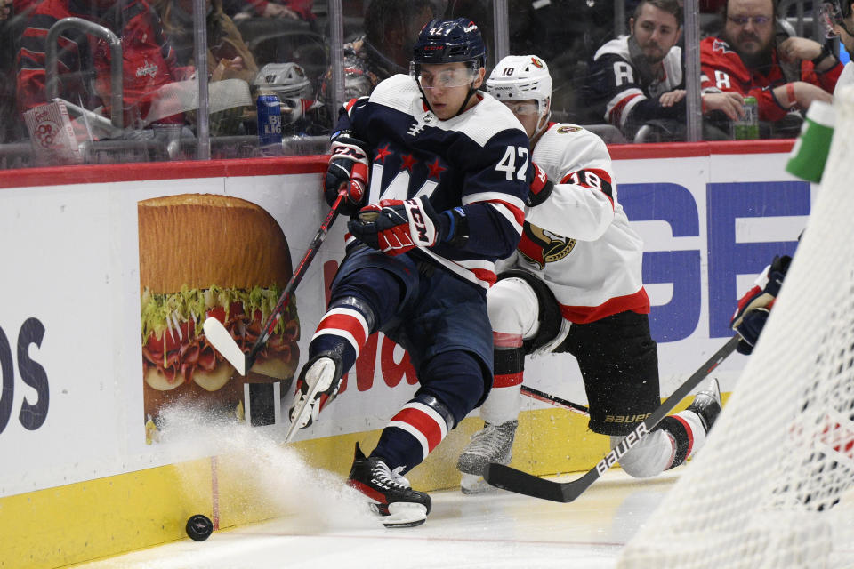 Washington Capitals defenseman Martin Fehervary (42) battles for the puck against Ottawa Senators left wing Tim Stutzle (18) during the second period of an NHL hockey game, Saturday, Jan. 22, 2022, in Washington. (AP Photo/Nick Wass)