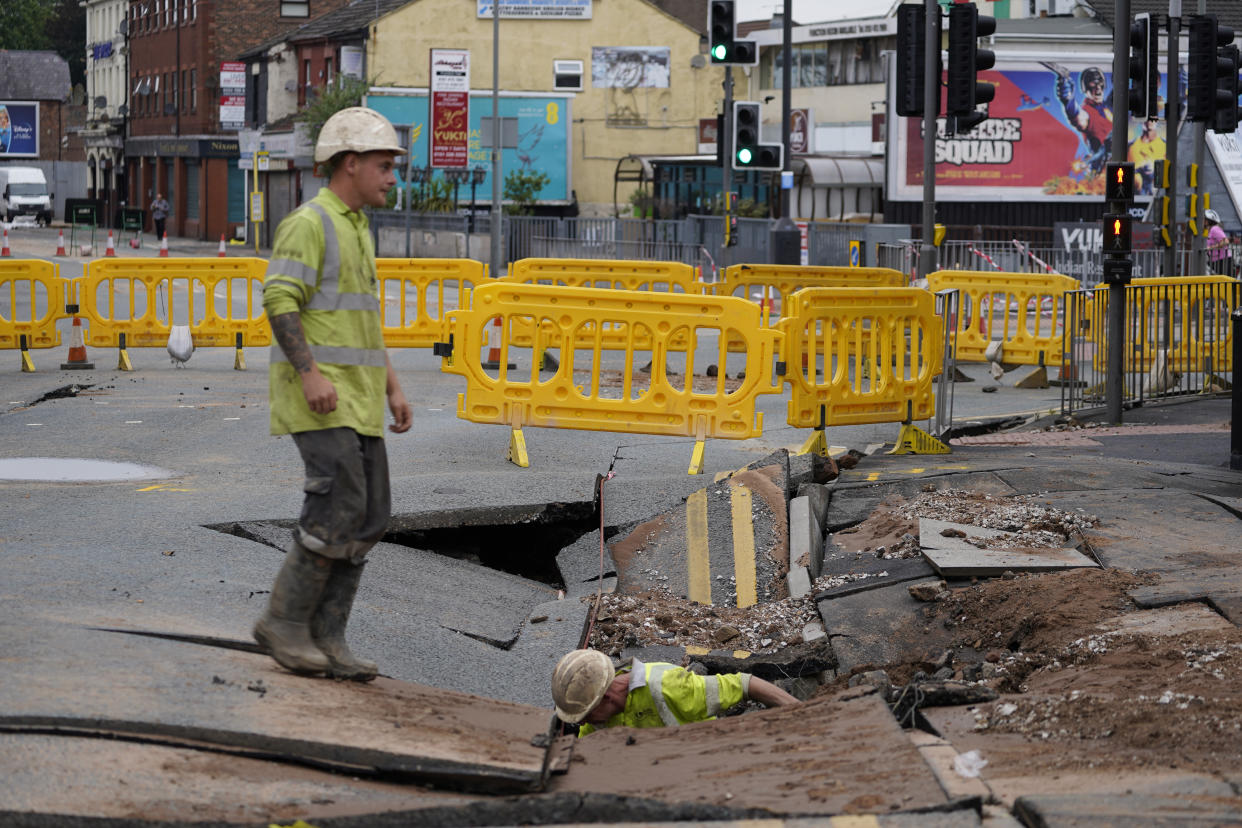 United Utilities workers inspect a 4.5 metre (15ft) by six metre (20ft) sinkhole in Green Lane, Old Swan, Liverpool, caused by a suspected ruptured water main. Picture date: Saturday July 24, 2021.