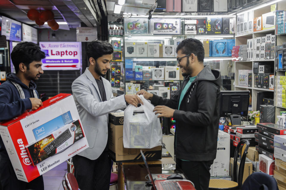 Customers buying computers and other digital accessories at a computer market in Dhaka, Bangladesh, Jan. 1, 2024. For decades, political battles in Bangladesh have been fought on the streets, often with violence, by parties led by two powerful women. But there are signs of a generational change as the country of 169 million heads into another general election Sunday. A burgeoning technology industry, lively e-commerce and growing public digital infrastructure are helping one of South Asia’s fastest growing economies capitalize on a tech-savvy workforce which is demanding change from politicians. (AP Photo/Mahmud Hossain Opu)