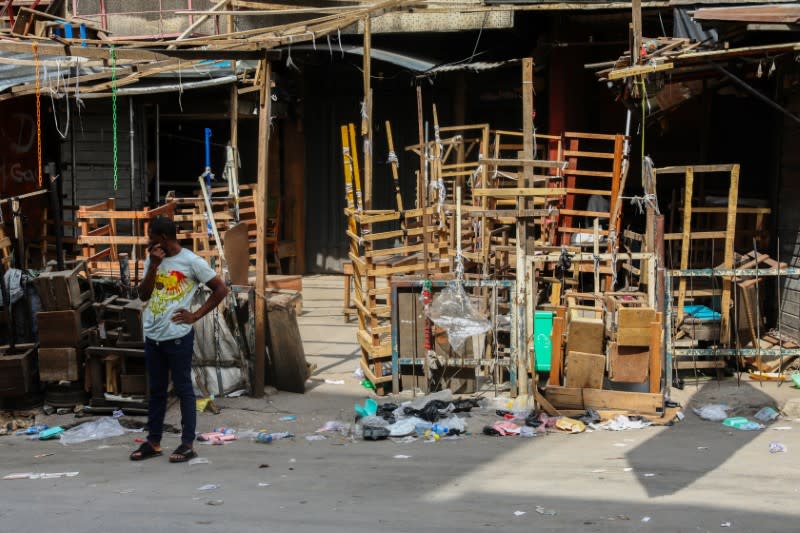 A man stands beside closed stalls in a nearly deserted wholesale market during lockdown by the authorities to limit the spread of coronavirus disease (COVID-19), in Lagos