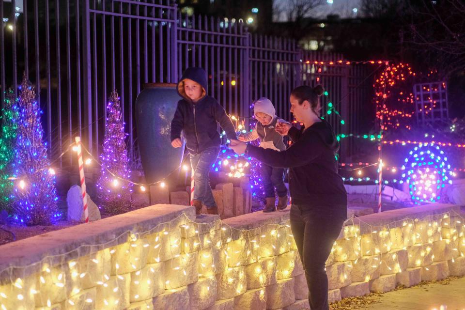 A mother guides her two children through the lights of the Amarillo Botanical Gardens in December 2022 at its Christmas in the Gardens event. This year's holiday spectacle begins Dec. 14 and continues through Dec. 23.