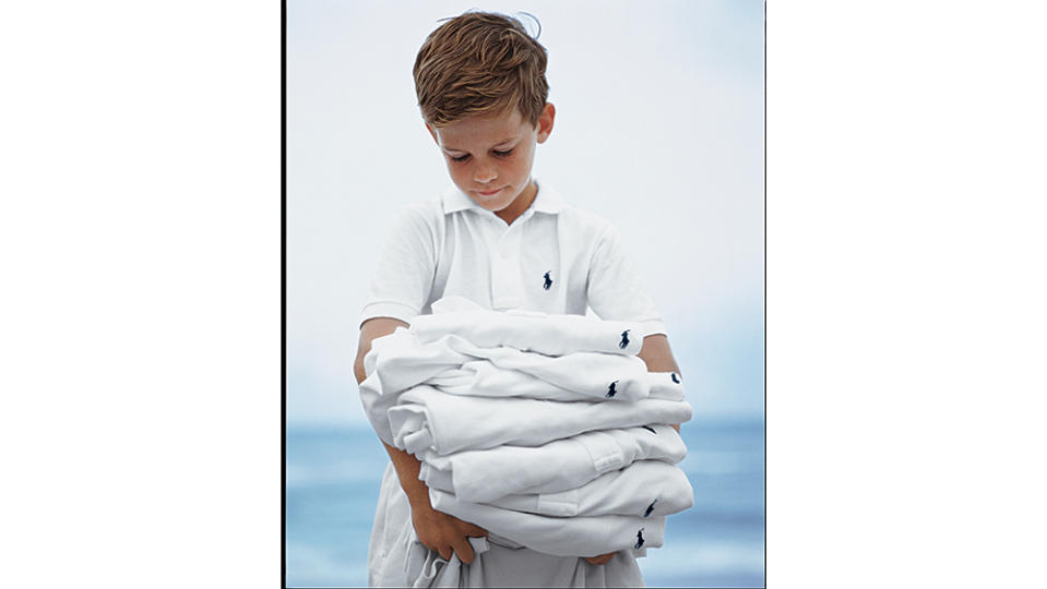 A kid holding a stack of polos, as seen in the new book. - Credit: Ralph Lauren