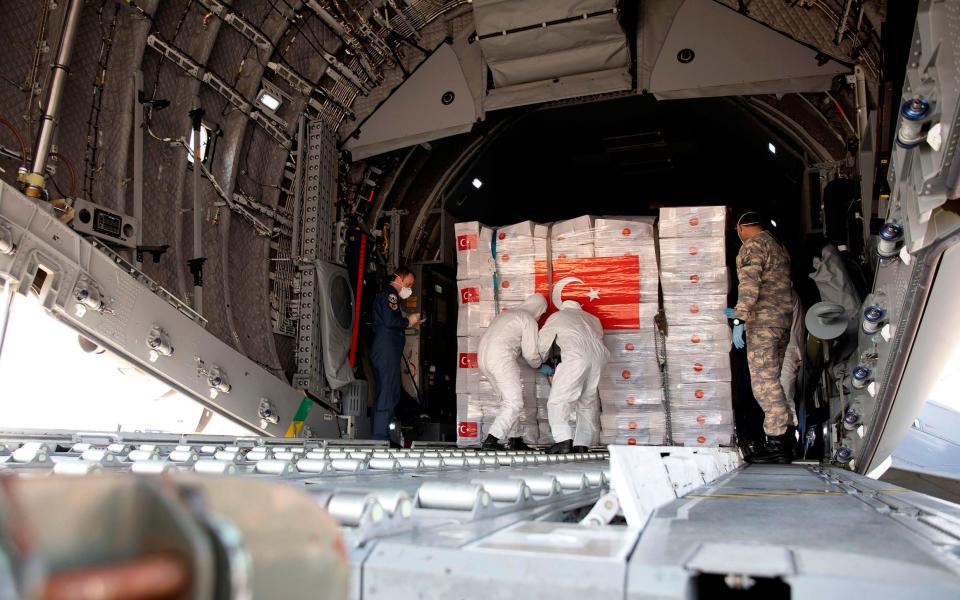 Workers unload boxes of PPE from one of the flights from Turkey - AFP