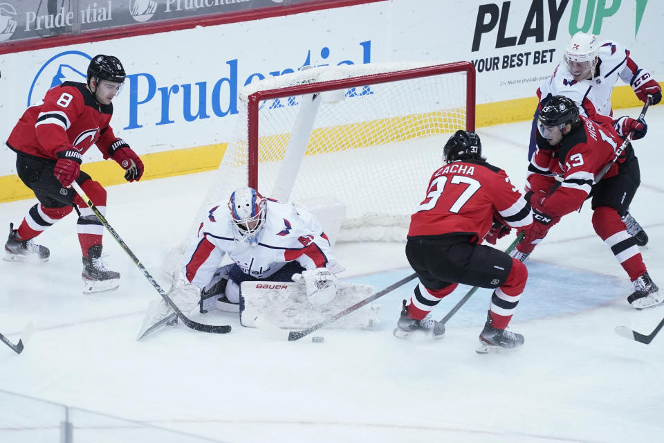 Washington Capitals goaltender Vitek Vanecek (41) tends net against New Jersey Devils defenseman Will Butcher (8) center Pavel Zacha (37) and center Nico Hischier (13) during the third period of an NHL hockey game, Saturday, Feb. 27, 2021, in Newark, N.J. (AP Photo/Mary Altaffer)