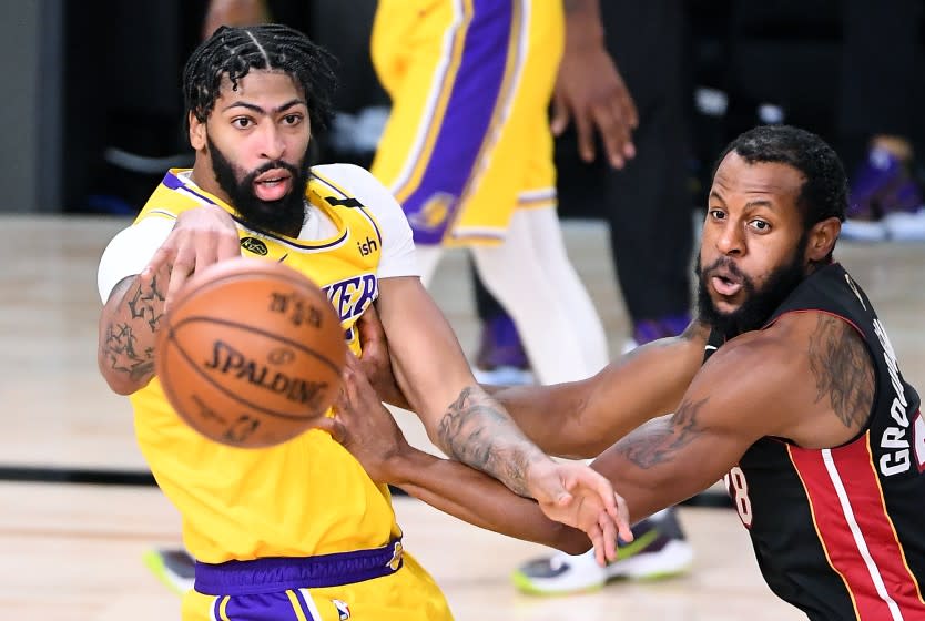 ORLANDO, FLORIDA OCTOBER 6, 2020-Lakers Anthony Davis gets a pass off in front of eat's Abndre Iguodala in the 2nd quarter in Game 4 of the NBA FInals in Orlando Sunday. (Wally Skalij/Los Angeles Times)